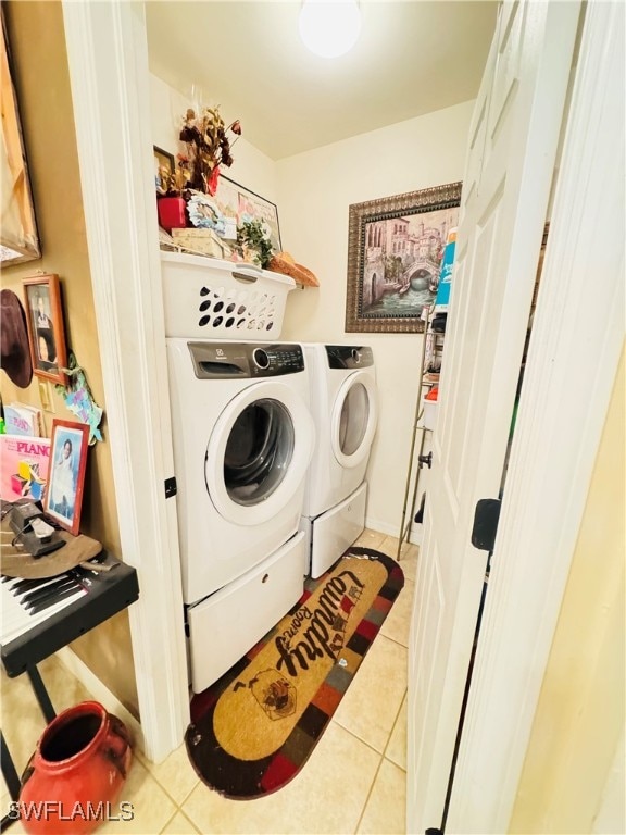 laundry area with light tile patterned flooring and washer and dryer