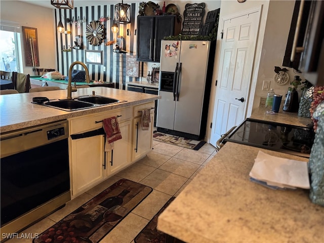 kitchen featuring decorative light fixtures, light tile patterned floors, sink, and appliances with stainless steel finishes