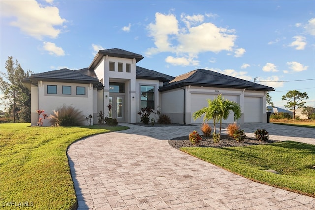 prairie-style home featuring a garage and a front lawn