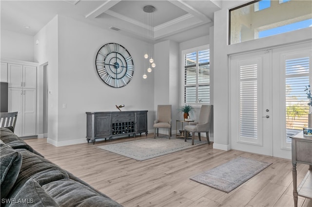 living room with plenty of natural light, ornamental molding, and light wood-type flooring