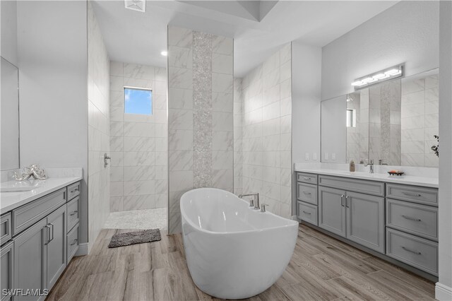 bathroom featuring hardwood / wood-style floors, vanity, and separate shower and tub