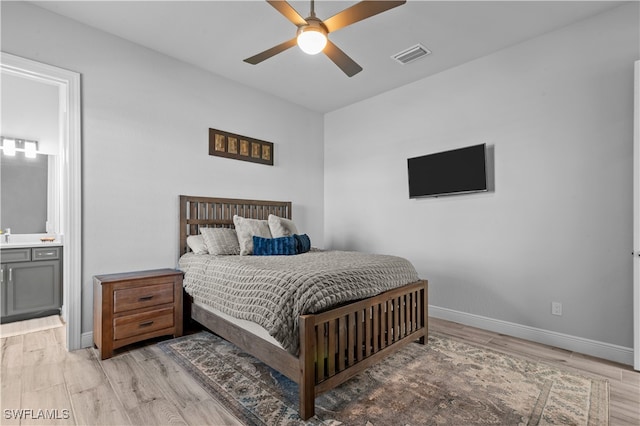 bedroom featuring ensuite bath, ceiling fan, and light wood-type flooring