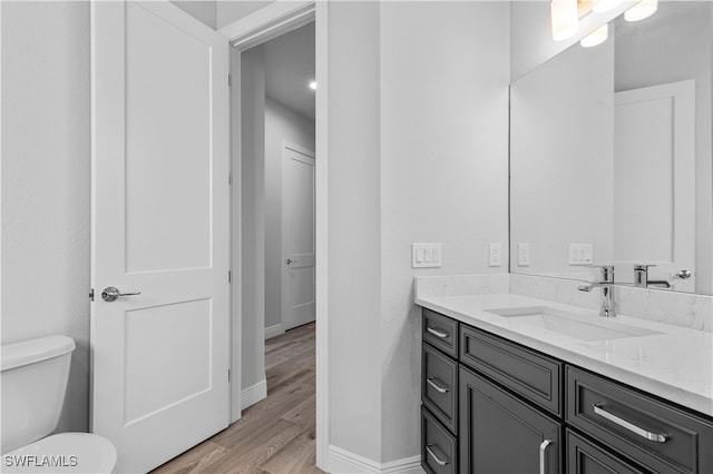 bathroom with vanity, wood-type flooring, and toilet