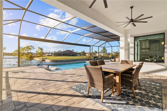 view of pool with a water view, glass enclosure, ceiling fan, and a patio area