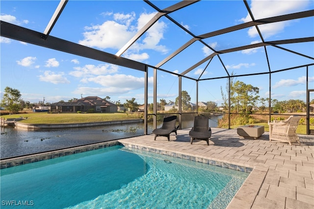 view of pool featuring glass enclosure, a water view, and a patio