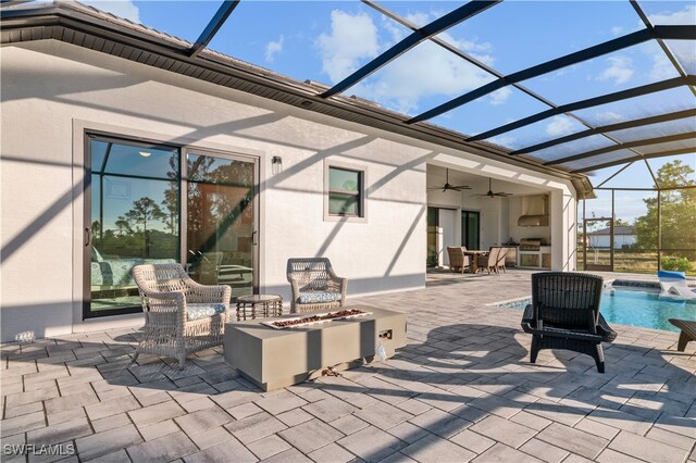 view of patio with glass enclosure, a fire pit, and ceiling fan