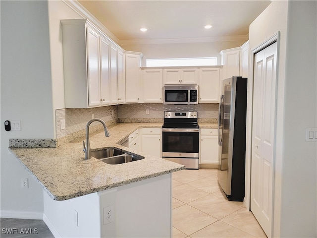 kitchen with white cabinetry, sink, light stone counters, kitchen peninsula, and appliances with stainless steel finishes