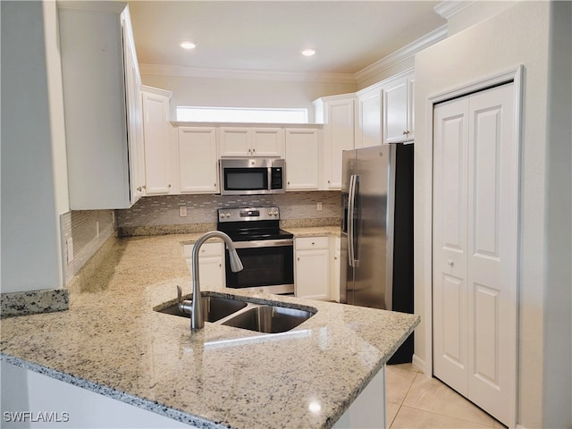 kitchen with kitchen peninsula, stainless steel appliances, light stone counters, and white cabinetry