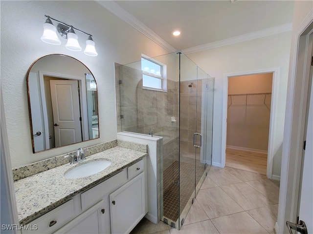 bathroom with vanity, tile patterned floors, a shower with door, and crown molding