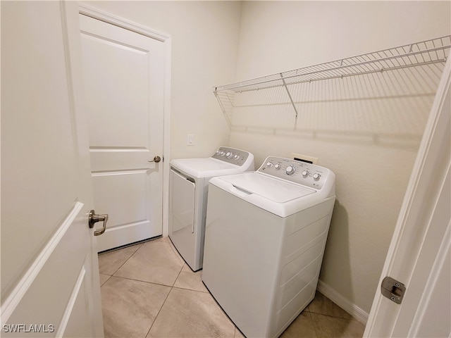 laundry room with washer and clothes dryer and light tile patterned floors