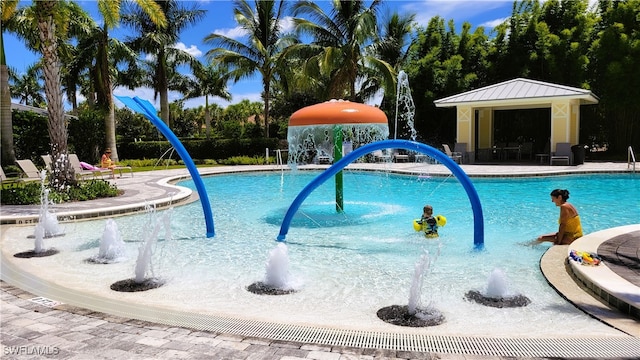 view of pool with pool water feature and a patio