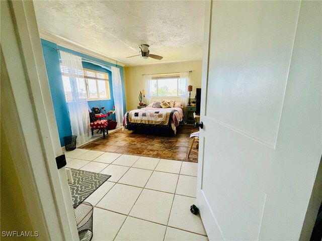 tiled bedroom featuring a textured ceiling and ceiling fan