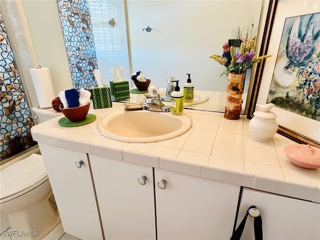 bathroom with toilet, vanity, and a shower with curtain