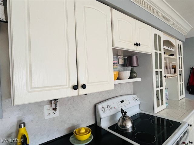 kitchen with backsplash, white cabinets, and white range with electric cooktop