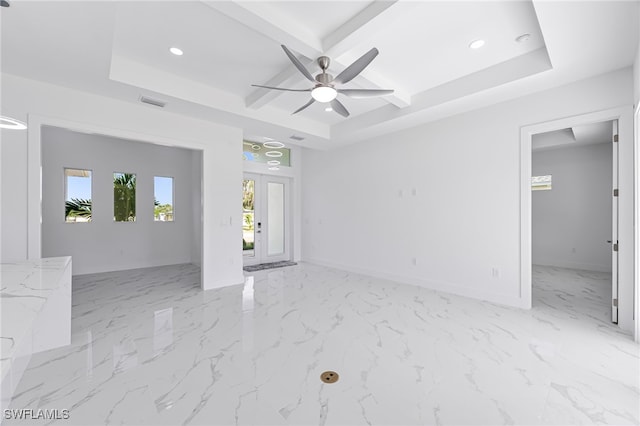 unfurnished room with ceiling fan and a raised ceiling