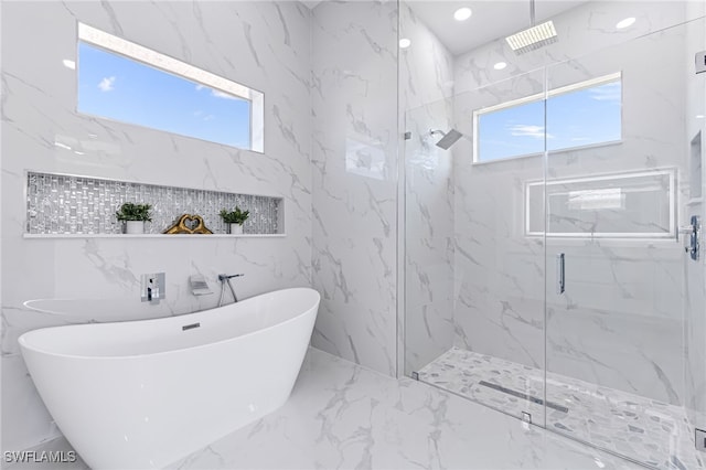 bathroom featuring plus walk in shower and tile walls