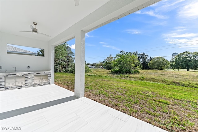 view of patio / terrace featuring ceiling fan and exterior kitchen