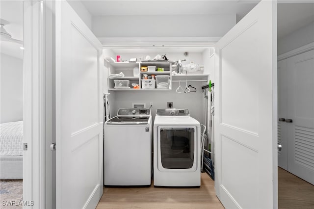 washroom featuring washing machine and dryer and light hardwood / wood-style floors