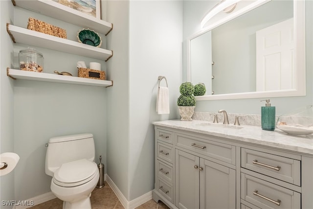 bathroom with tile patterned flooring, vanity, and toilet