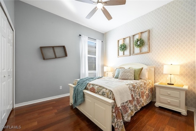 bedroom with ceiling fan, dark wood-type flooring, and a closet