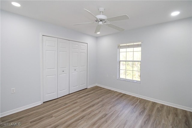 unfurnished bedroom featuring a closet, ceiling fan, and light wood-type flooring