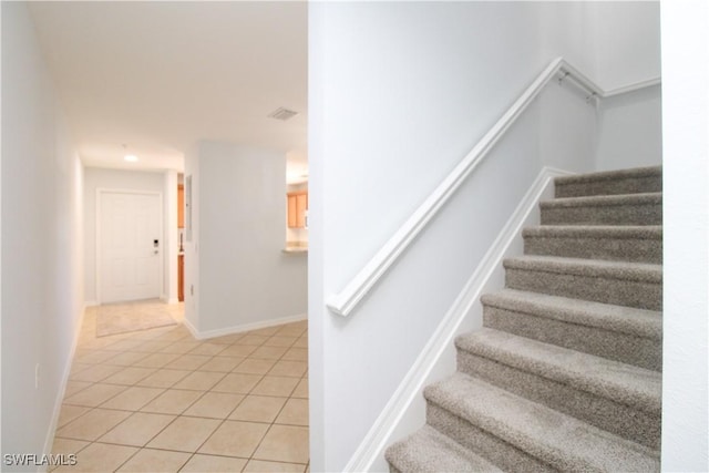 stairway with tile patterned floors