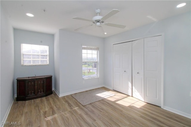 unfurnished bedroom featuring light hardwood / wood-style floors, a closet, and ceiling fan