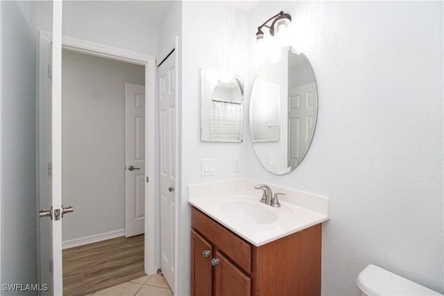 bathroom with toilet, tile patterned flooring, and vanity