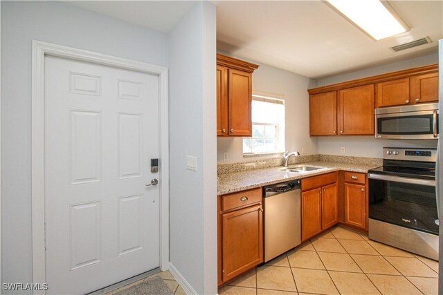 kitchen with sink, light tile patterned flooring, and stainless steel appliances