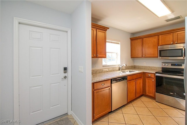 kitchen with sink, light tile patterned floors, and stainless steel appliances