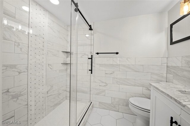 bathroom with tile patterned floors, walk in shower, vanity, tile walls, and toilet