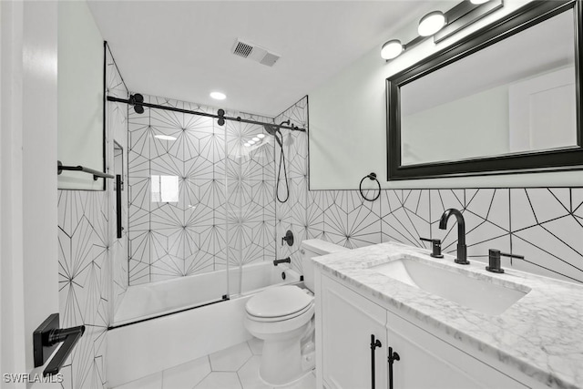 full bathroom featuring enclosed tub / shower combo, tile patterned floors, toilet, vanity, and tile walls