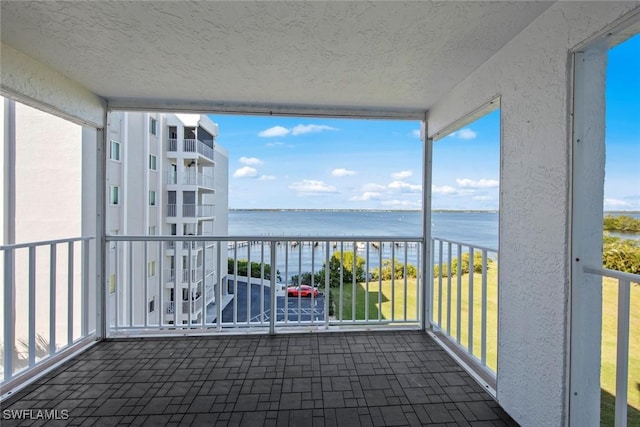 unfurnished sunroom with a water view