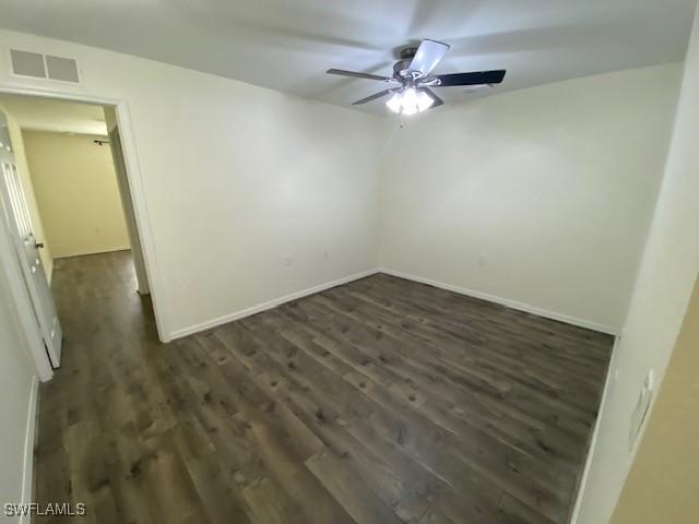 empty room with ceiling fan and dark hardwood / wood-style floors