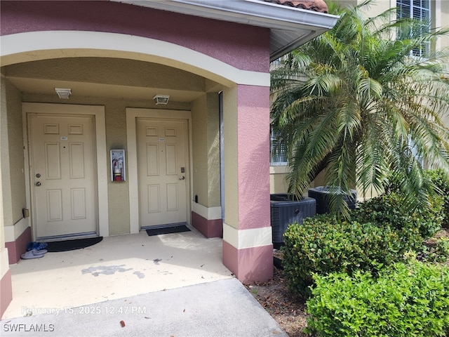 view of exterior entry with central air condition unit