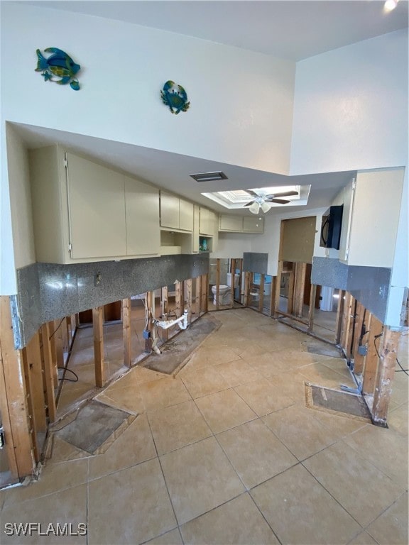 kitchen with cream cabinetry, light tile patterned floors, and tasteful backsplash