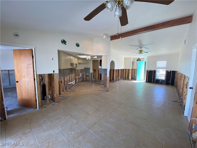 tiled empty room with beamed ceiling and ceiling fan