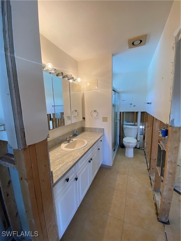 bathroom featuring tile patterned flooring, vanity, and toilet