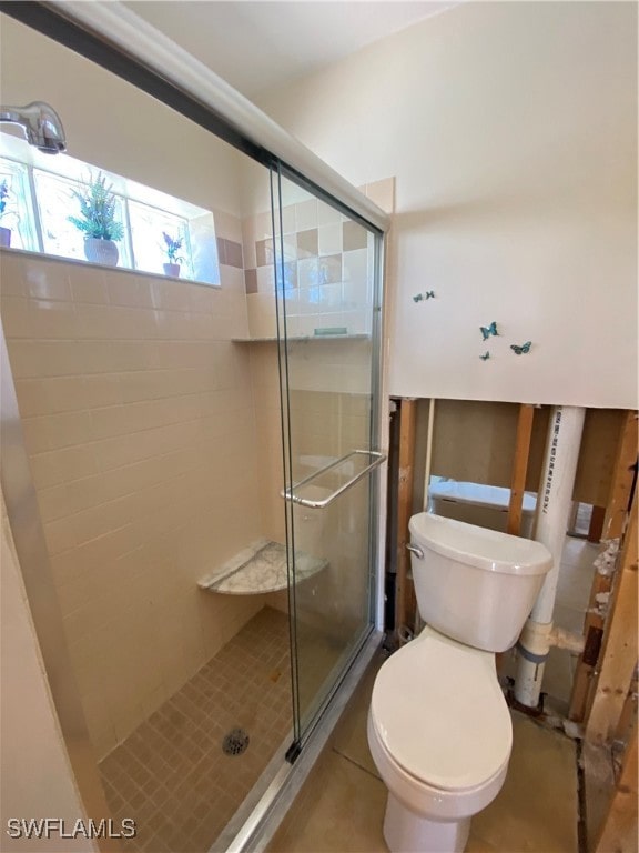 bathroom with walk in shower, tile patterned floors, and toilet