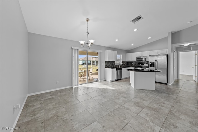 kitchen featuring an inviting chandelier, pendant lighting, vaulted ceiling, white cabinets, and appliances with stainless steel finishes