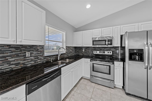 kitchen featuring white cabinetry, sink, stainless steel appliances, and vaulted ceiling