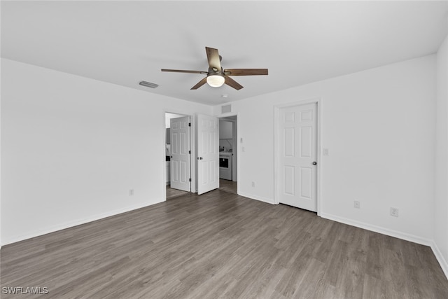 unfurnished bedroom featuring washer / dryer, ceiling fan, and hardwood / wood-style flooring