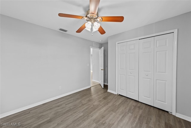 unfurnished bedroom featuring ceiling fan, a closet, and light wood-type flooring