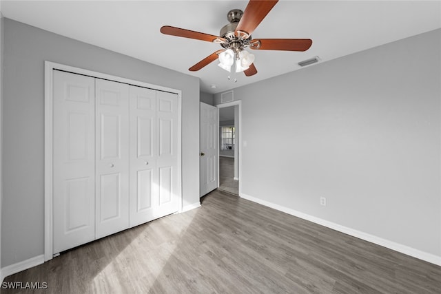 unfurnished bedroom with light wood-type flooring, a closet, and ceiling fan