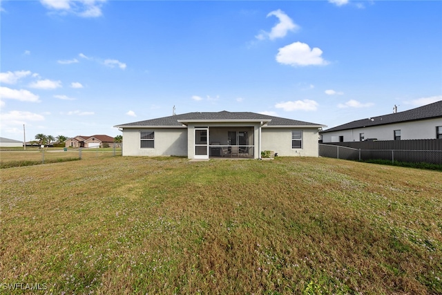 back of property featuring a lawn and a sunroom