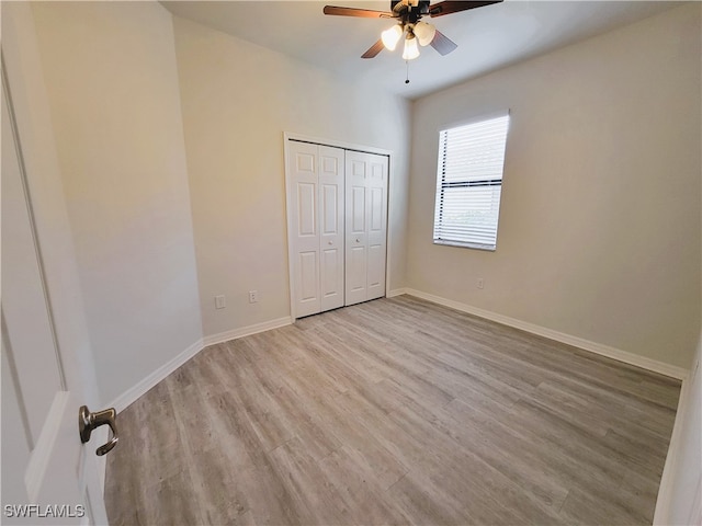 unfurnished bedroom with ceiling fan, a closet, and light hardwood / wood-style flooring