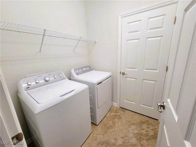 laundry room featuring light tile patterned floors and washer and clothes dryer