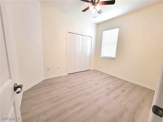 unfurnished bedroom featuring light hardwood / wood-style floors, a closet, and ceiling fan