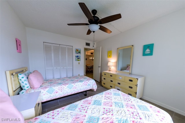 tiled bedroom featuring ceiling fan, a closet, and a textured ceiling