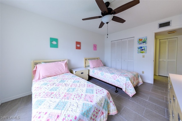 bedroom with dark tile patterned flooring, a closet, visible vents, and baseboards